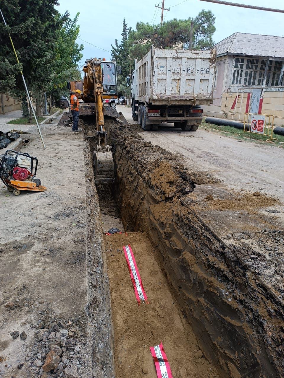 Xəbərdarlıq lenti döşənmiş xəndəyin geri doldurulması